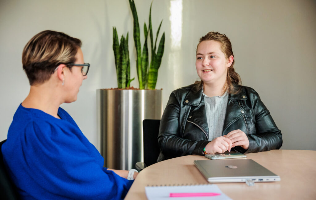 Scholier met stagebegeleider in gesprek aan tafel